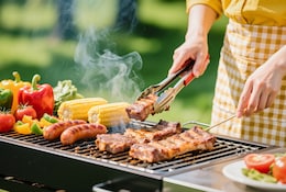 Jeune femme préparant un barbecue.