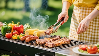 Jeune femme préparant un barbecue.