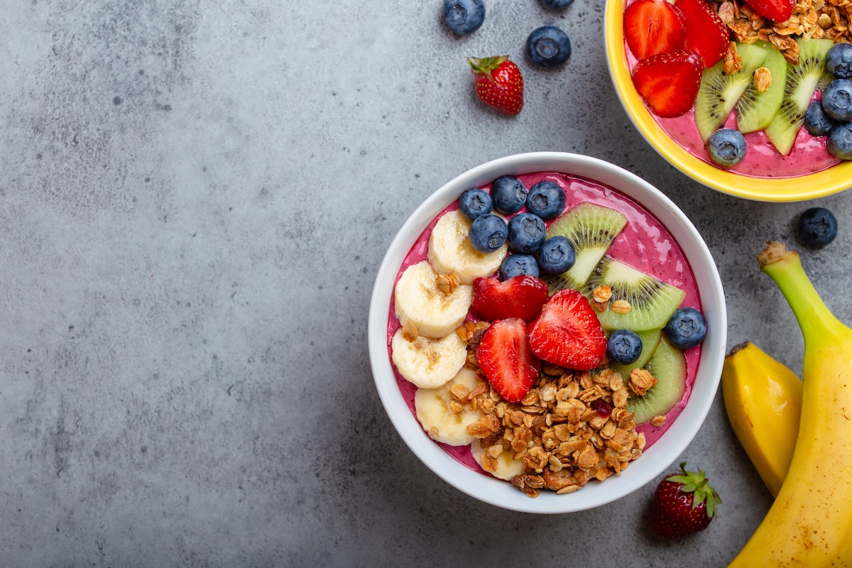 Bowl smoothie acai avec fraises, banane, bleuets, kiwi et granola.