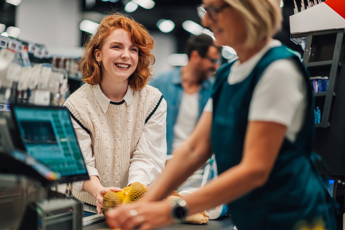 Cliente souriante à la caisse d'une boutique