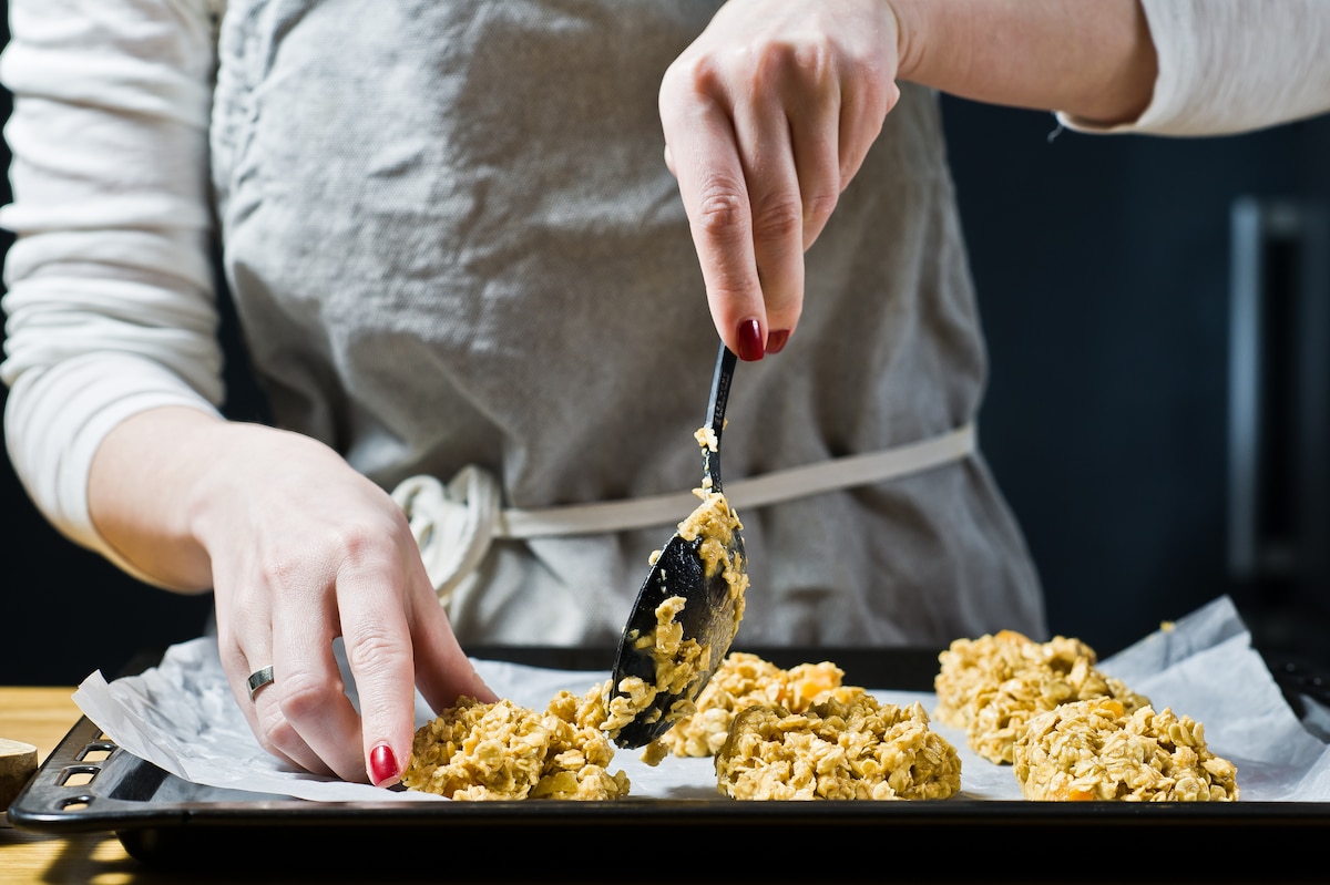Femme préparant du granola et leur donnant forme avec une cuillère à soupe