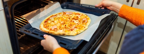 Femme sortant une pizza du four