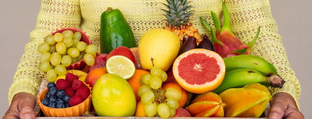 Femme tenant un panier rempli de fruits