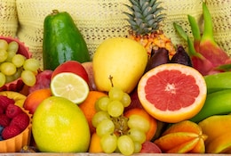 Femme tenant un panier rempli de fruits