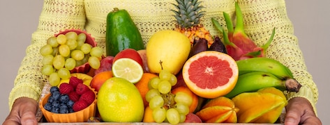 Femme tenant un panier rempli de fruits
