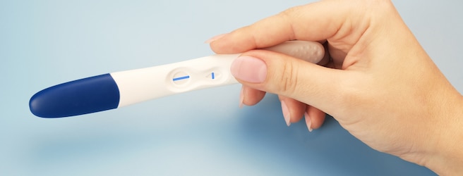 Femme tenant un test de grossesse