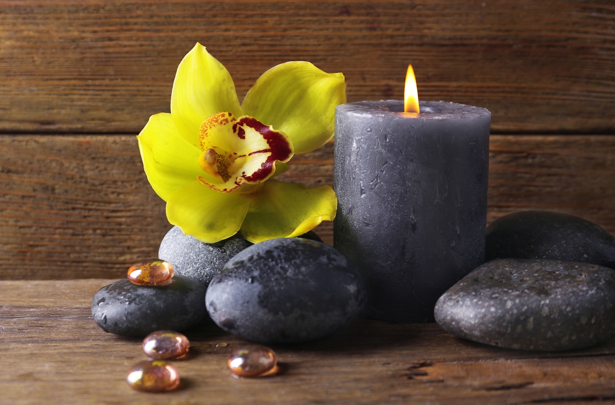 Fleur jaune et bougies sur fond en bois