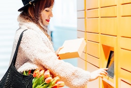 Jeune femme récupérant un colis dans un locker