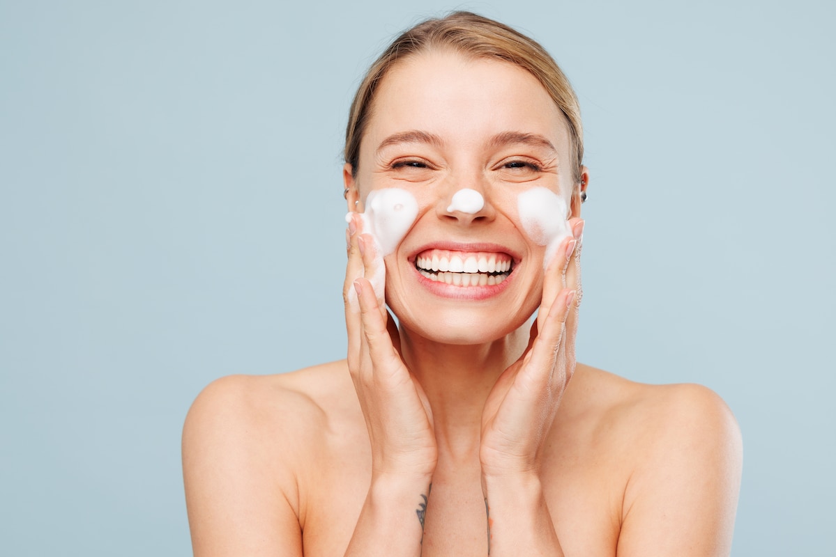 Jeune femme souriante se massant le visage