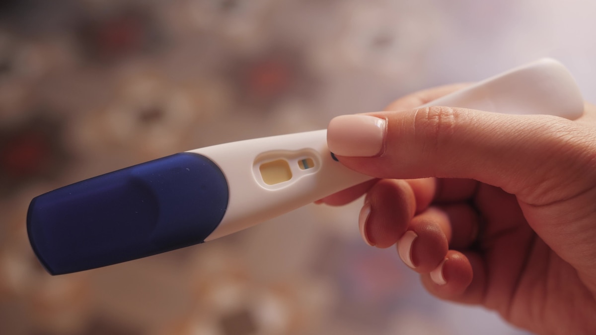 Jeune femme tenant un test de grossesse
