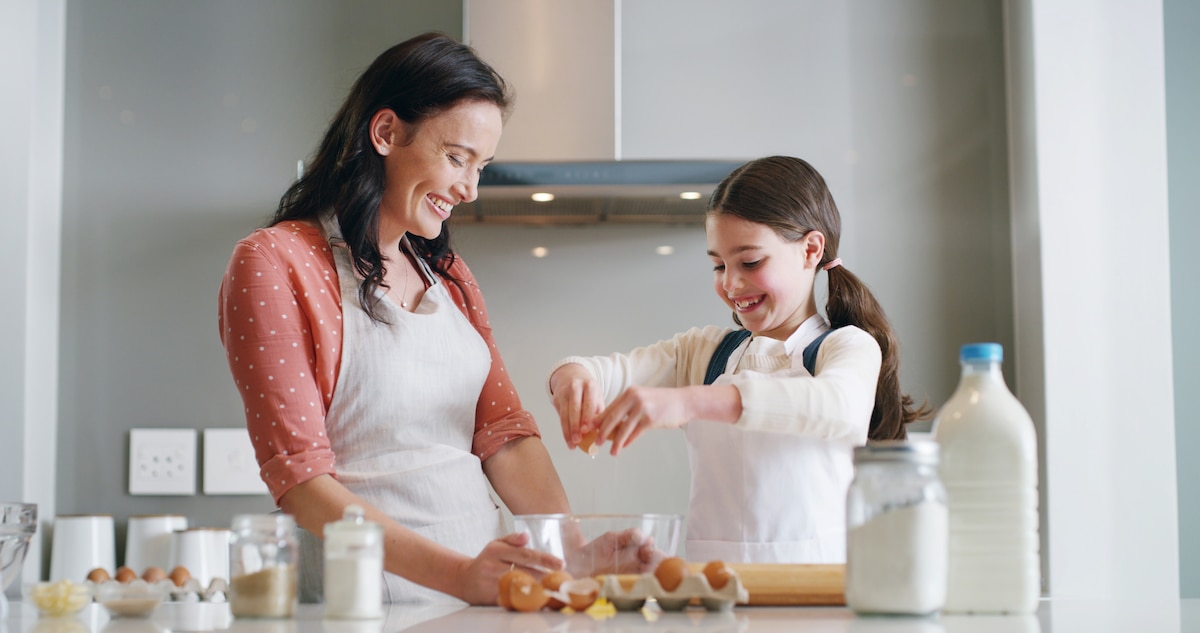 Jeune mère de famille et sa fille cuisinent ensemble.