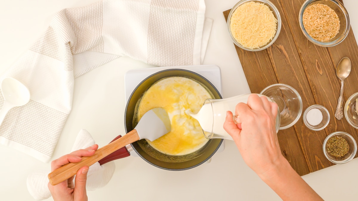 Préparation de la sauce Alfredo en y ajoutant du lait.