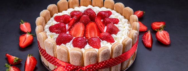 Charlotte aux fraises fait maison sur fond noir.
