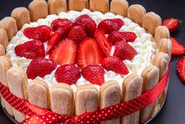 Charlotte aux fraises fait maison sur fond noir.