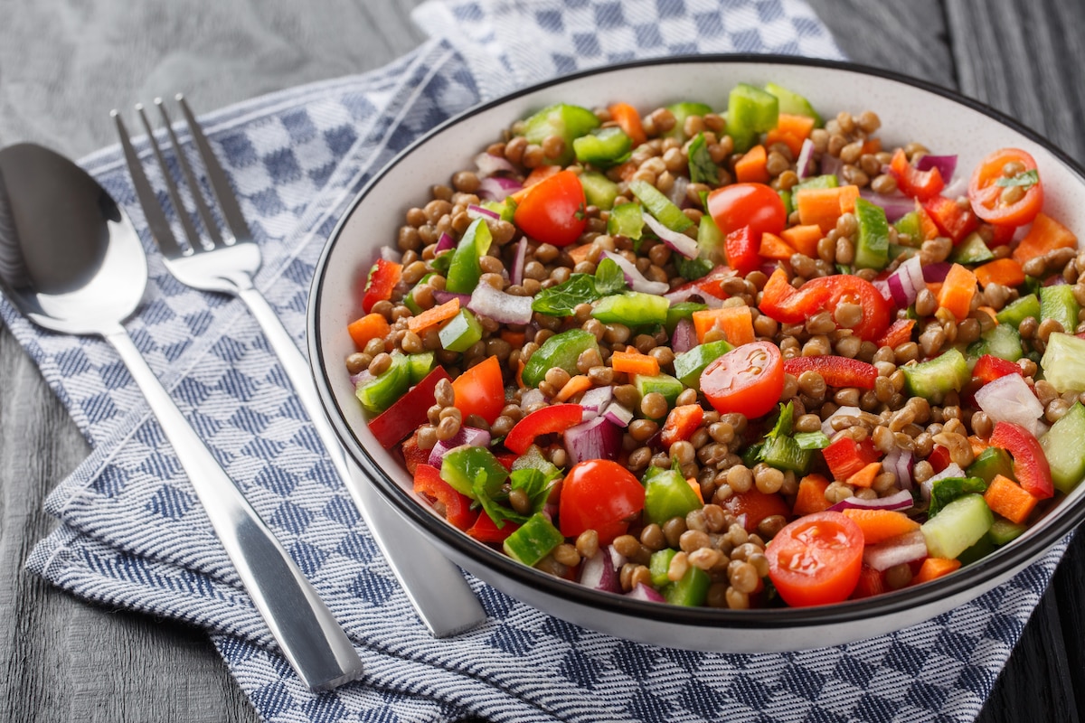 Salade végétarienne aux lentilles bouillies, tomates, poivrons, concombres, oignons assaisonnés d'huile d'olive