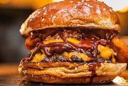 Gros plan sur un smash burger appétissant rempli de sauce bbq.
