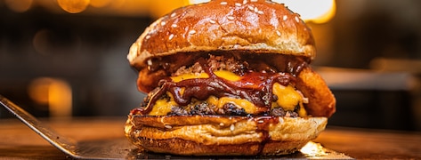 Gros plan sur un smash burger appétissant rempli de sauce bbq.