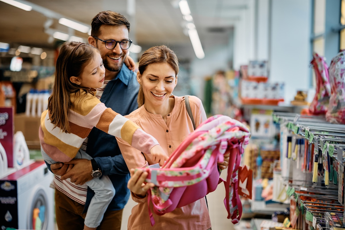 famille achetant un cartable pour leur fille