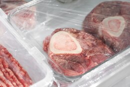 Steaks de boeuf congelés et viande hachée dans des contenants sur l'étagère du réfrigérateur, en gros plan