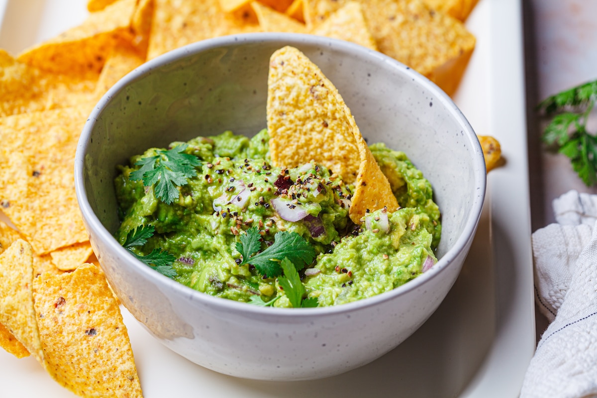 Bol rempli de guacamole avec chips tortilla