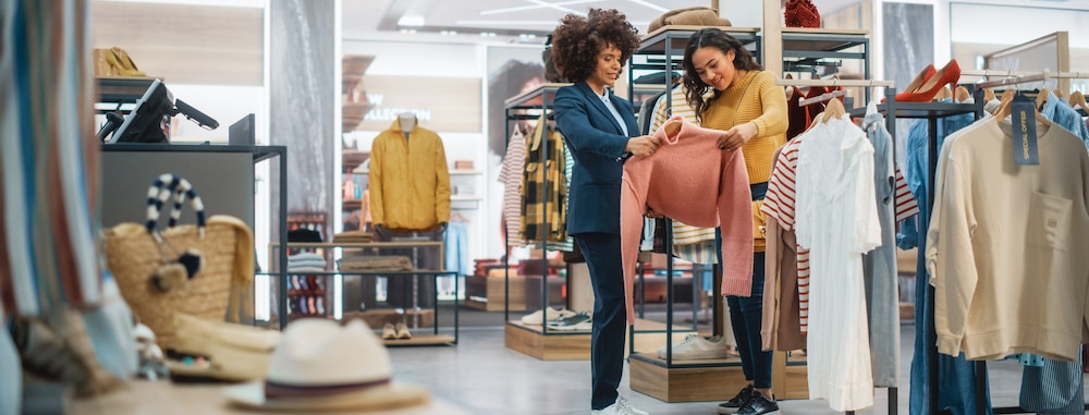 Deux femmes choisissant un vêtement dans un magasin.