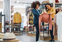 Deux femmes choisissant un vêtement dans un magasin.