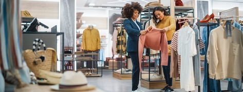 Deux femmes choisissant un vêtement dans un magasin.
