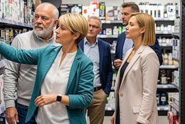Groupe de personnes dans un magasin regardant des produits électroménagers et des équipements de jardinage/bricolage.