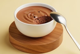 Mousse au chocolat dans un petit bol blanc avec une petite cuillère à café.