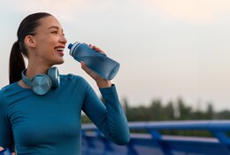 Jeune femme sportive buvant dans une gourde.