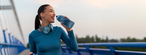 Jeune femme sportive buvant dans une gourde.