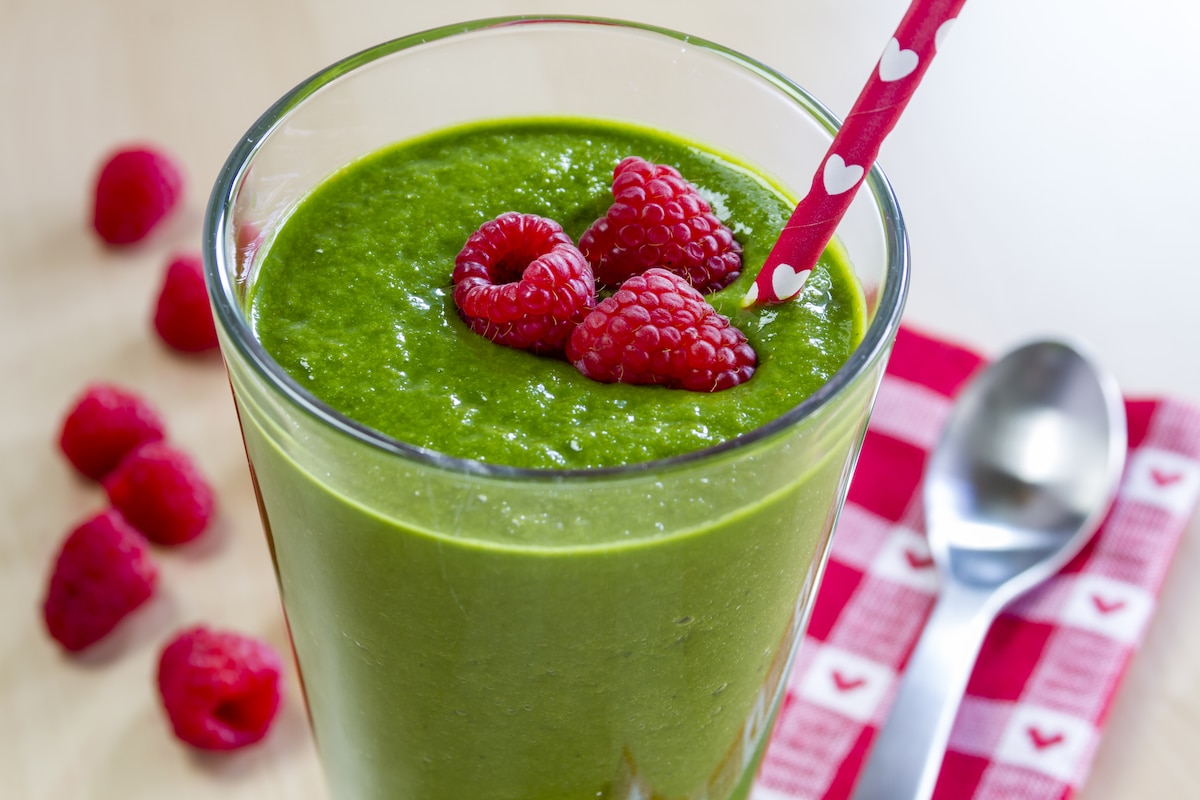 Verre de smoothie fruits rouges épinards.