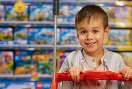 Jeune garçon souriant dans un magasin de jouets.