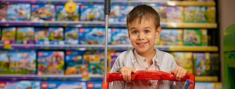 Jeune garçon souriant dans un magasin de jouets.